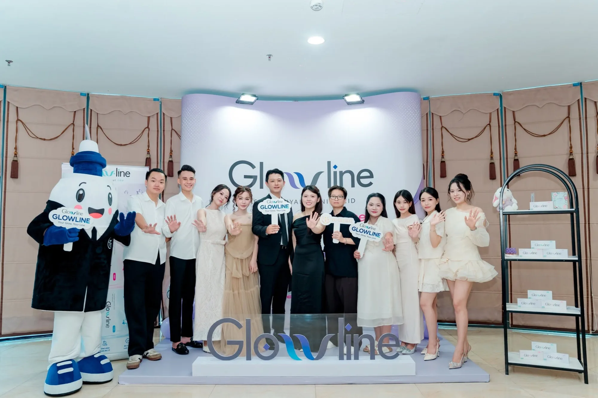 The photograph shows Glowline representatives, aesthetic professionals, and event guests posing together on stage at the Glowline Filler clinical insights event.